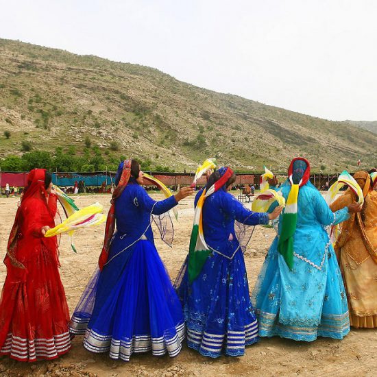 female nomads dancing with dastmal near their tent in nature.