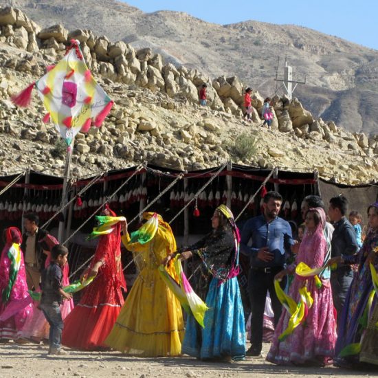 female nomads dancing with dastmal near their tent in nature.