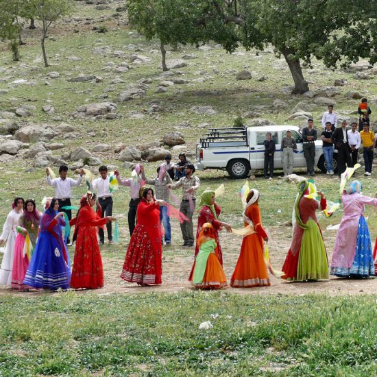 nomads wearing colorful clothes, dancing together with dastmal in their wedding party, nomadic lifestyle, Iran