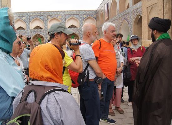 tourist listening to clergy, to learn more about Islam, Iran