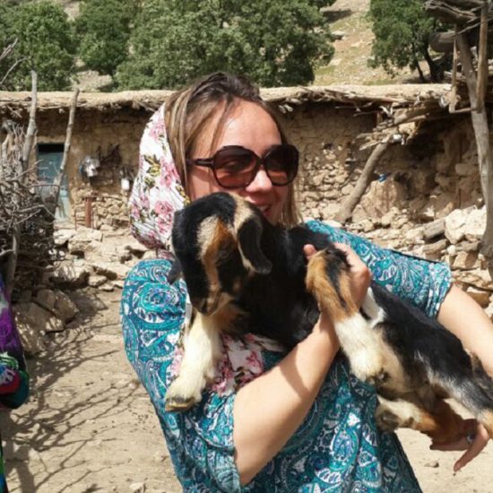 nomads hosted tourists, the tourist hugs a tiny lamb, Fars nomads, Iran