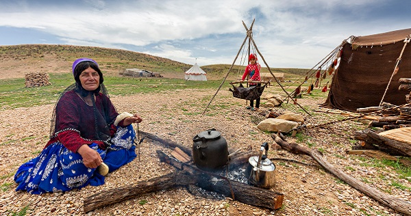 a nomadic woman sitting near fire and having wool in her hand, nomadic lifestyle, Iran