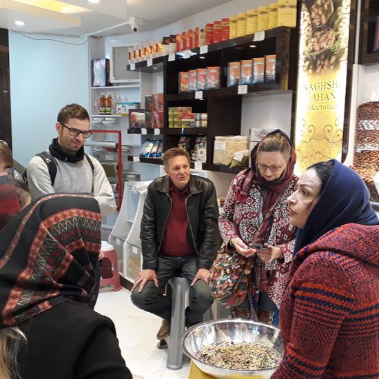 tourists in Isfahan bazaar learning about iranian spice, Iran