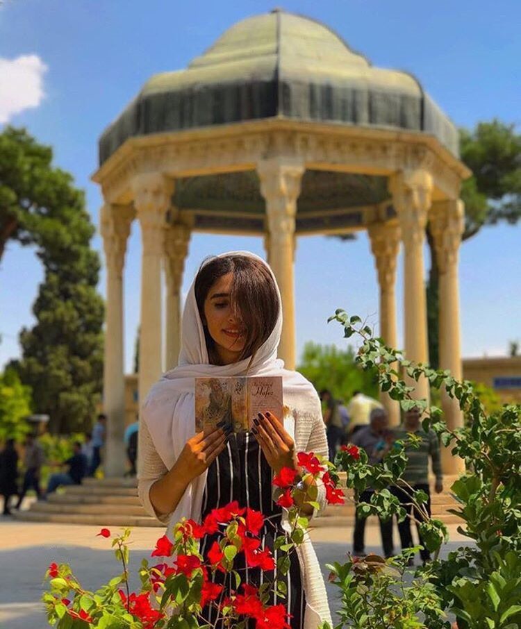 Iranian girl reading book of Hafez poetry at tomb of hafez, hafez tomb, hafezieh