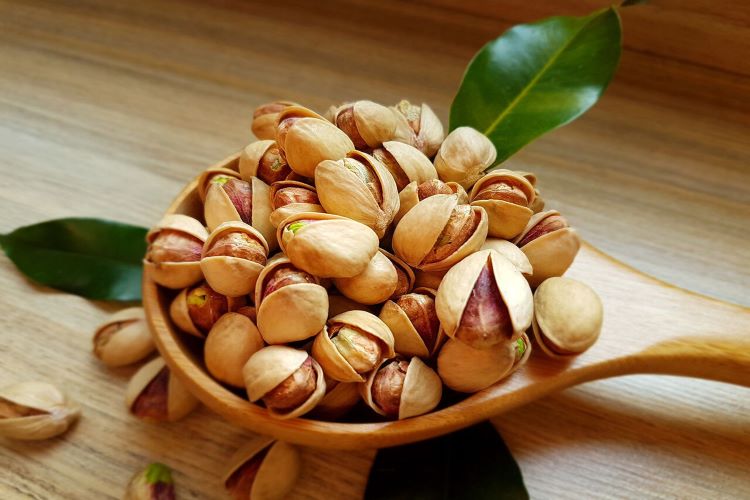 some pistachios in wooden dish - Gifts from Iran